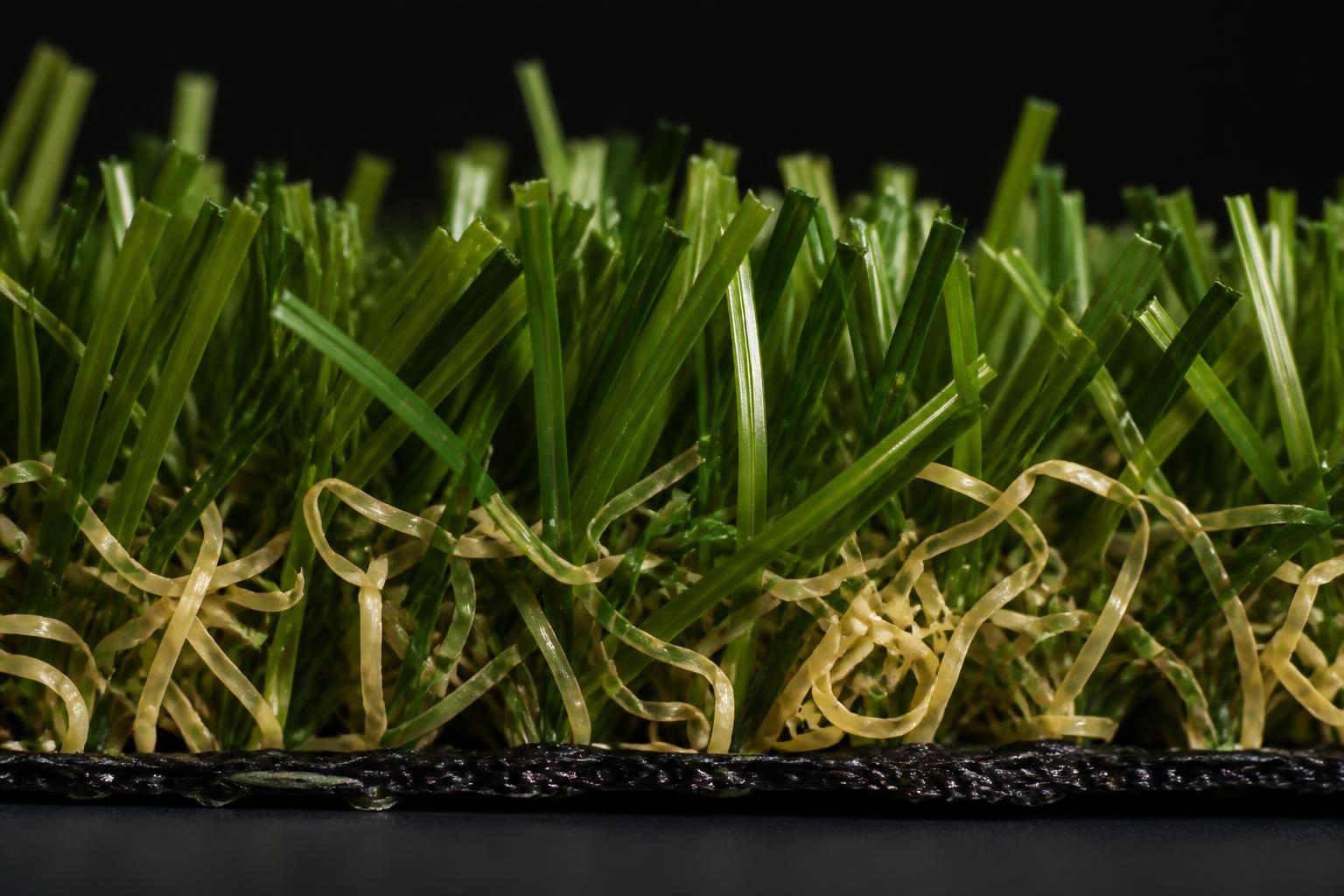 Macro close-up of premium dual-tone artificial turf blades and thatch
